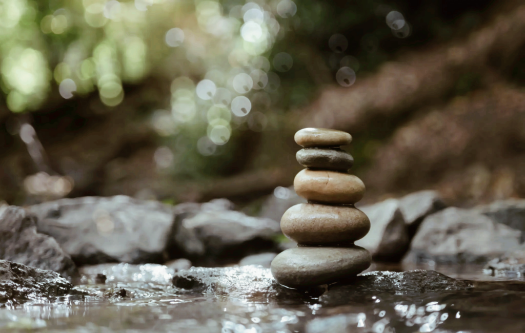 A stack of rocks in the water on top of each other.